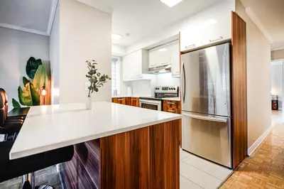 a kitchen with a white counter and a refrigerator at Appartement chaleureux pour un séjour parfait in Montréal