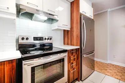 a kitchen with a stove and a refrigerator at Appartement chaleureux pour un séjour parfait in Montréal