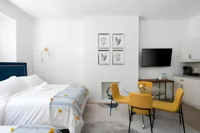 a bedroom with a bed and two chairs and a desk at Kozy Stays Drummond Modern apartments in Montréal