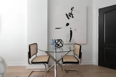 a dining room with a glass table and chairs at Kozy Stays Drummond Modern apartments in Montréal