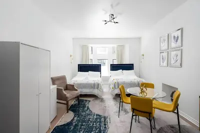 a bedroom with two beds and a table and chairs at Kozy Stays Drummond Modern apartments in Montréal