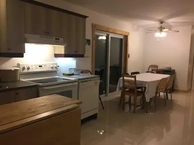 a kitchen with a table and a dining room at Charming chalet for rent next to Owl Head SKI in Potton