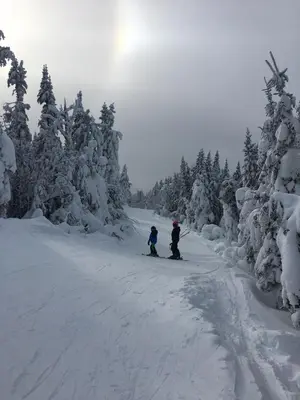 two people are skiing down a snow covered road at Charming chalet for rent next to Owl Head SKI in Potton