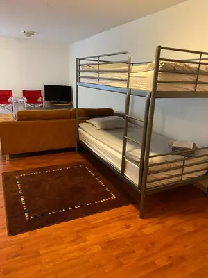 a room with two bunk beds and a couch at Charming chalet for rent next to Owl Head SKI in Potton