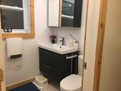 a bathroom with a sink and a toilet and a window at Charming chalet for rent next to Owl Head SKI in Potton