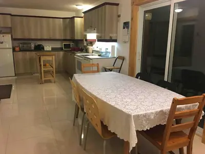 a kitchen with a table and some chairs and a table and a kitchen at Charming chalet for rent next to Owl Head SKI in Potton