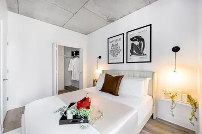 a bedroom with a large white bed with a red bag on it at Charming Champs Élysées -Old Montreal-Downtown Montreal - Laundry in Montréal