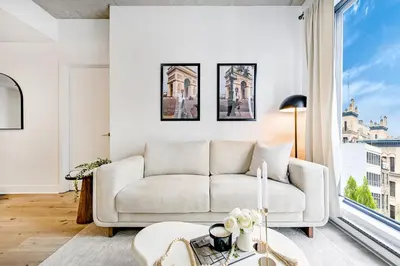 a living room with a couch and a large window at Charming Champs Élysées -Old Montreal-Downtown Montreal - Laundry in Montréal