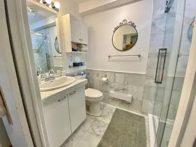 a bathroom with a sink and a toilet and a mirror at Montreal Hideaway in a Residential area in Montréal
