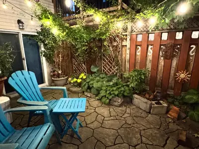 two blue chairs sitting on a patio at night at Montreal Hideaway in a Residential area in Montréal