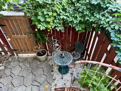 a garden with a table and chairs and a fence at Montreal Hideaway in a Residential area in Montréal