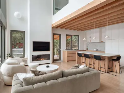 a living room with a couch and a kitchen at Wild Pond Villa in Mansonville