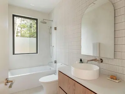 a bathroom with a sink and a toilet and a window at Wild Pond Villa in Mansonville