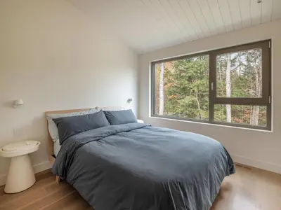 a bedroom with a large bed and a window at Wild Pond Villa in Mansonville