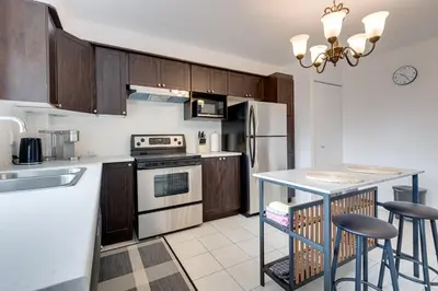 a kitchen with wooden cabinets and a counter top at 2CAC rénover, tranquille, près du parc, commodités et activités in Montréal