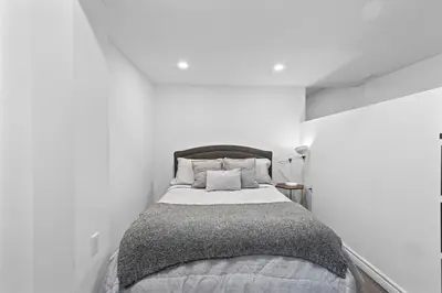 a white bedroom with a bed in a white wall at NEW LOFT -WIFI -Quiet -Tohu -Easy Transit -Park in Montréal