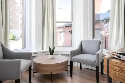 a living room with two chairs and a table at Kozy Stays Penfield - Modern Rooms Heart of downtown in Montréal