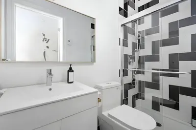 a bathroom with a sink and a toilet and a mirror at Kozy Stays Penfield - Modern Rooms Heart of downtown in Montréal
