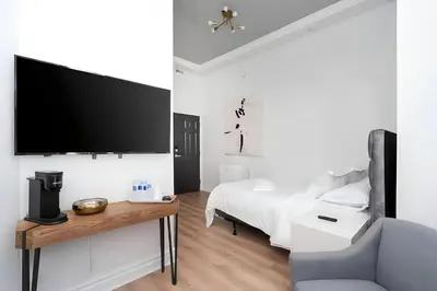 a bedroom with a bed and a flat screen tv at Kozy Stays Penfield - Modern Rooms Heart of downtown in Montréal