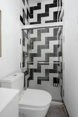 a bathroom with a toilet and a geometric wall at Kozy Stays Penfield - Modern Rooms Heart of downtown in Montréal