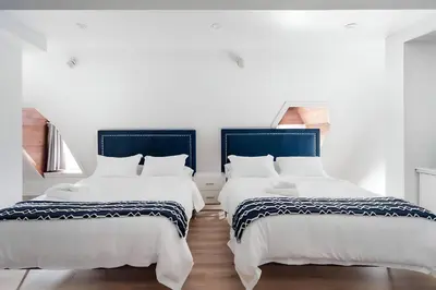 two beds sitting next to each other in a room at Kozy Stays Penfield - Modern Rooms Heart of downtown in Montréal