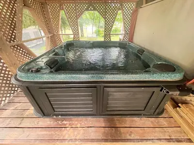 a bath tub sitting on top of a wooden floor at Beautiful cottage waterfront in Trois-Lacs