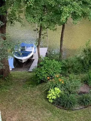 a boat is docked at a dock in the water at Beautiful cottage waterfront in Trois-Lacs