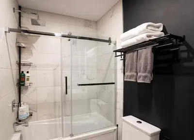 a bathroom with a shower with a glass door at 204 - Modern Cozy Suite with 2BR, Gym, Parking, DT & Airport in Montréal