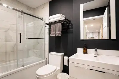 a bathroom with a toilet and a sink and a shower at 204 - Modern Cozy Suite with 2BR, Gym, Parking, DT & Airport in Montréal