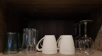 a group of glasses and bottles on a shelf at 204 - Modern Cozy Suite with 2BR, Gym, Parking, DT & Airport in Montréal