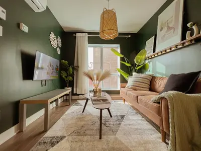 a living room with a brown couch and green walls at 205 - Cozy Green Oasis 1987 Collection with 2BR,Parking,DT in Montréal