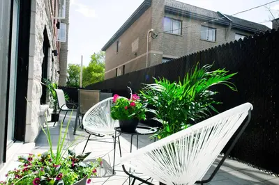 a patio with white chairs and potted plants at 103 - Bright Modern 2BR, Near DT W Street Parking in Montréal