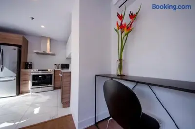 a kitchen with a vase of red flowers on a counter at 103 - Bright Modern 2BR, Near DT W Street Parking in Montréal