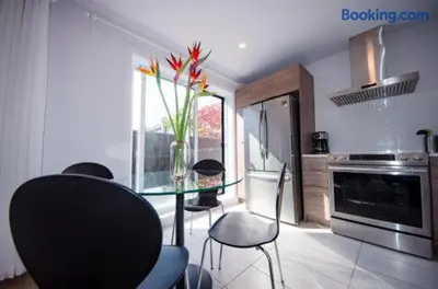 a kitchen with a glass table with a vase of flowers at 103 - Bright Modern 2BR, Near DT W Street Parking in Montréal