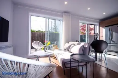 a living room with a couch and tables and windows at 103 - Bright Modern 2BR, Near DT W Street Parking in Montréal