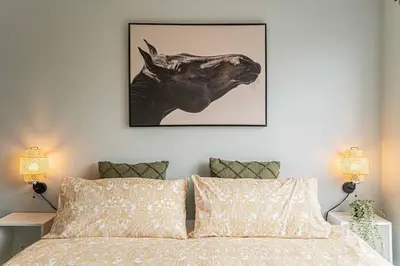 a bed with a black and white picture of a rhino at 107 - Sleek New 2BR Apt with Patio, Parking, DT&Airport in Montréal