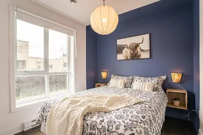 a bedroom with a bed and a large window at 107 - Sleek New 2BR Apt with Patio, Parking, DT&Airport in Montréal