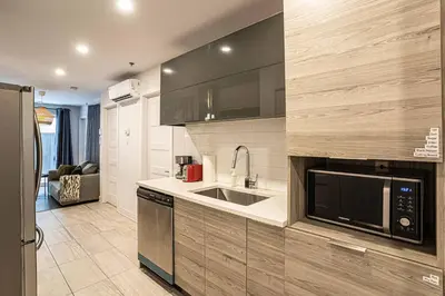 a kitchen with a sink and a microwave at 107 - Sleek New 2BR Apt with Patio, Parking, DT&Airport in Montréal