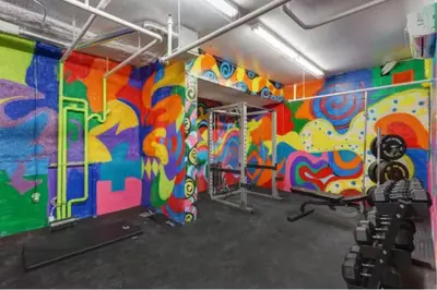 a gym with a colorful painting on the wall at 107 - Sleek New 2BR Apt with Patio, Parking, DT&Airport in Montréal