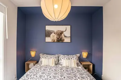 a bedroom with blue walls and a bed with a bull on it at 107 - Sleek New 2BR Apt with Patio, Parking, DT&Airport in Montréal