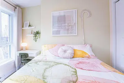 a bedroom with a bed with colorful pillows on it at 112 - Spacious 1BR Getaway, Gym, Paid Parking in Montréal