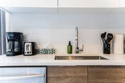 a kitchen with a sink and a coffee maker at 112 - Spacious 1BR Getaway, Gym, Paid Parking in Montréal