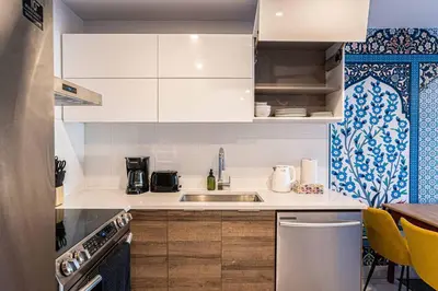 a kitchen with white cabinets and a sink at 117 - Spacious 2 King BD with Parking, Near DT & Airport in Montréal