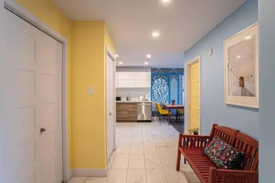 a living room with a bench and a kitchen at 117 - Spacious 2 King BD with Parking, Near DT & Airport in Montréal