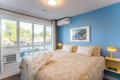 a bedroom with a bed with blue walls and a window at 117 - Spacious 2 King BD with Parking, Near DT & Airport in Montréal
