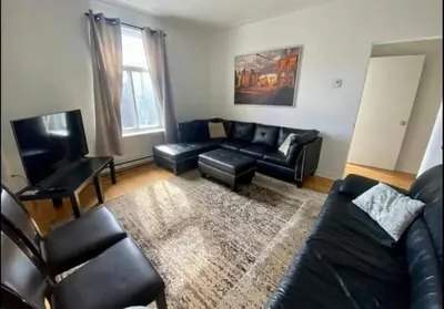 a living room with a black leather couch and a television at FULL KITCHEN 6min from DTOWN Room B in Montréal