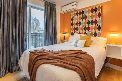 a bedroom with a bed and a large window at 119 - Vibrant Chic Designer 2BR with Gym,Parking,Airport&DT in Montréal