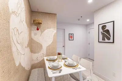 a dining room with a white table and chairs at 119 - Vibrant Chic Designer 2BR with Gym,Parking,Airport&DT in Montréal