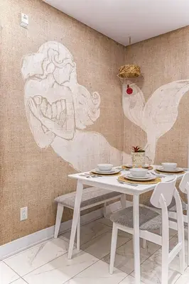 a table with two chairs and a wall with drawings on it at 119 - Vibrant Chic Designer 2BR with Gym,Parking,Airport&DT in Montréal