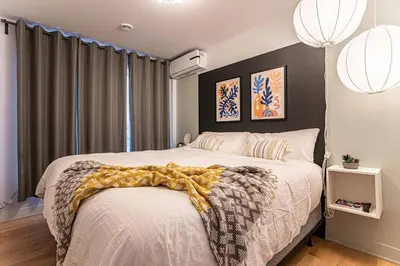 a bedroom with a bed with a blanket on it at 119 - Vibrant Chic Designer 2BR with Gym,Parking,Airport&DT in Montréal